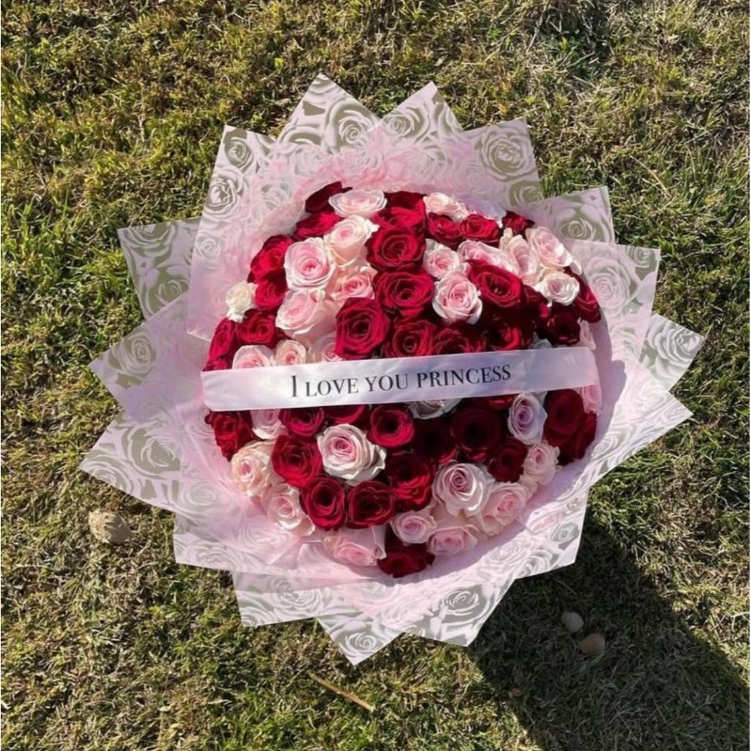 A round bouquet of red and pink roses wrapped in pink wrapping with a white ribbon that reads 'I LOVE YOU PRINCESS'.